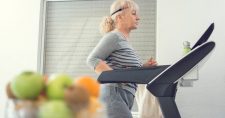 Elderly lady working out on the treadmill in her home.